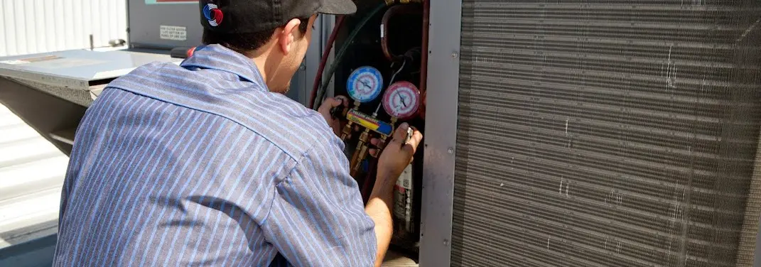HVAC technician servicing a condenser unit in Grandwood Park