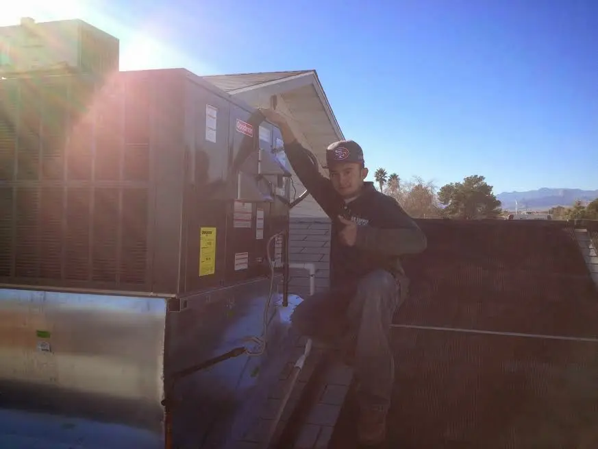HVAC technician performing Air Duct Cleaning on a rooftop unit in Grandwood Park